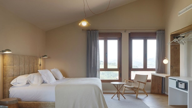 A bedroom with a bed, bedside lamps, a desk, and a chair. - Olivi1948 - Boutique Guesthouse (Usurbil)