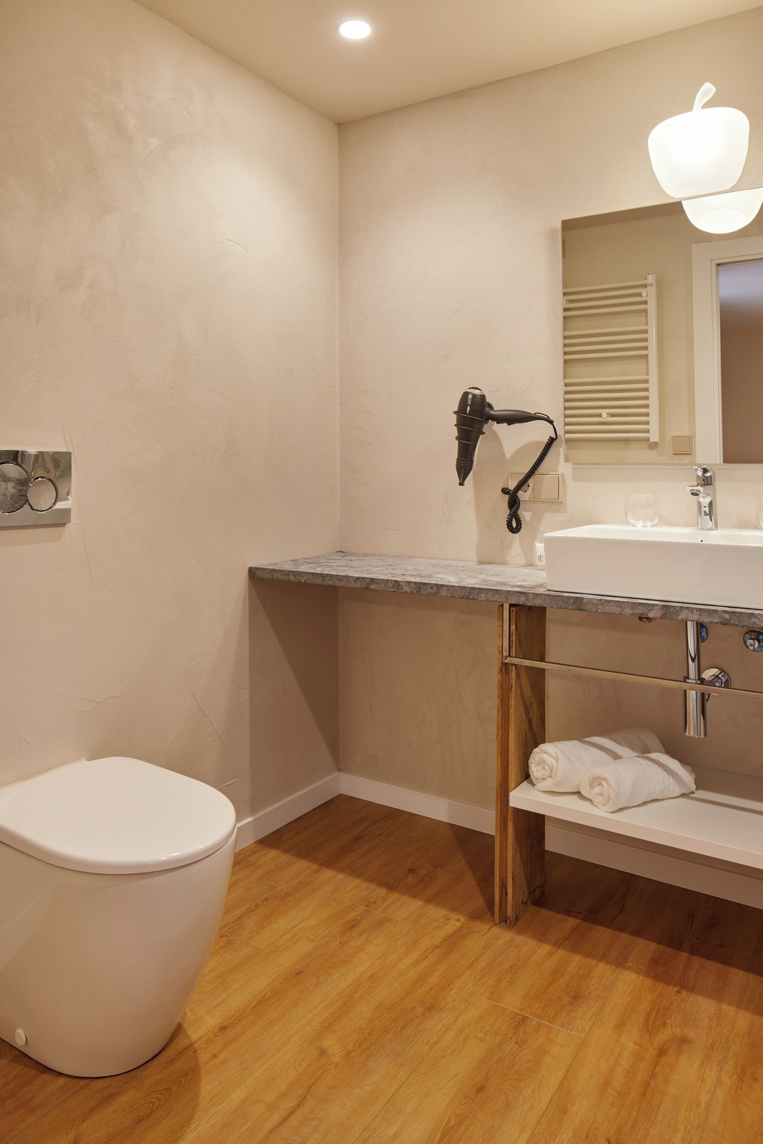 A bathroom with a white toilet, a sink with a mirror above it, and a towel rack.
