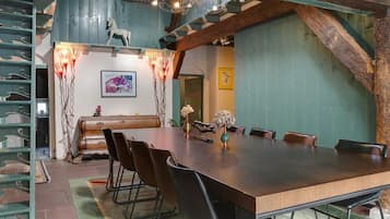 Une salle de conférence avec une longue table, des chaises et un vase décoratif.