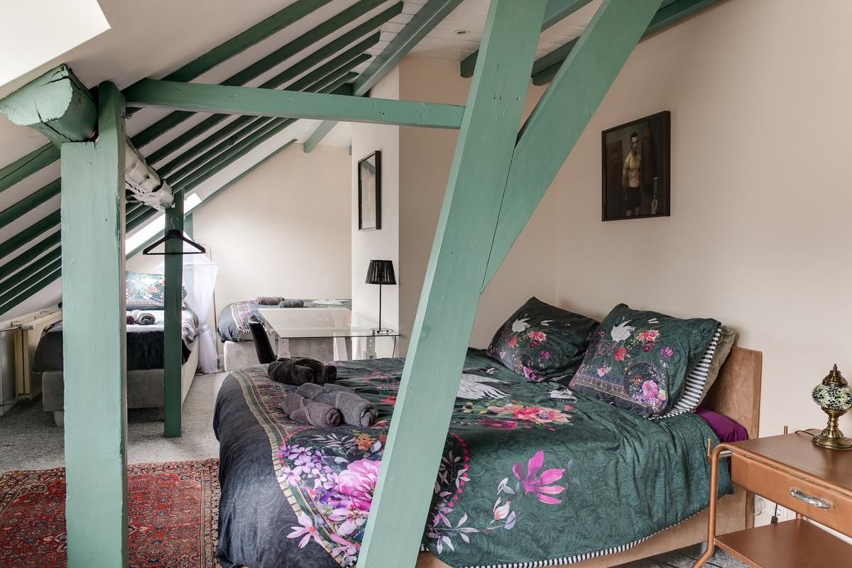 Een slaapkamer met een bed, een bureau en een stoel.