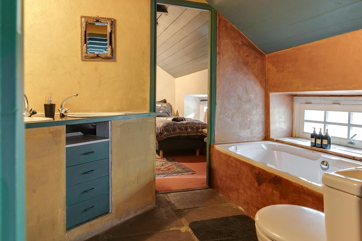 Un baño con bañera, inodoro y lavabo con espejo.