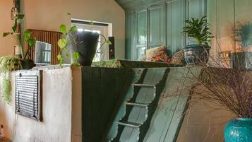 A staircase leading to a landing with a view of the interior, a potted plant, and a wooden bench.