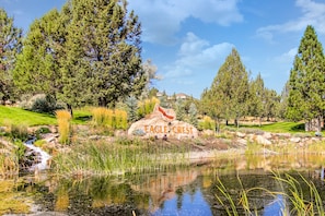 Escape to a serene destination surrounded by a tranquil pond and lush greenery, perfect for relaxation and outdoor activities.