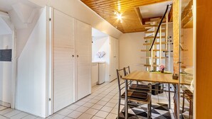 Una cucina moderna con mobili bianchi, un tavolo in legno e una scala che conduce a un piano superiore.