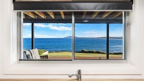 A window with a view of the sea and a grassy area. - Amaroo - Uninterrupted 180 degree water views (Gerroa)