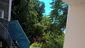 A patio with a table and chairs, a staircase, and a view of greenery. - STUDIO 400 M FROM THE OCEAN TERRACE, PARKING AND BIKE SHELTER AVAILABLE (La Rochelle)