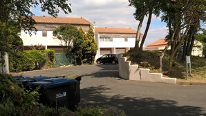 A residential street with houses, a parked car, and a dumpster. - STUDIO 400 M FROM THE OCEAN TERRACE, PARKING AND BIKE SHELTER AVAILABLE (La Rochelle)