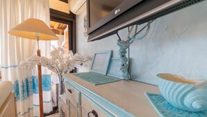 A vintage-style room with a dresser, a lamp, and decorative items.
