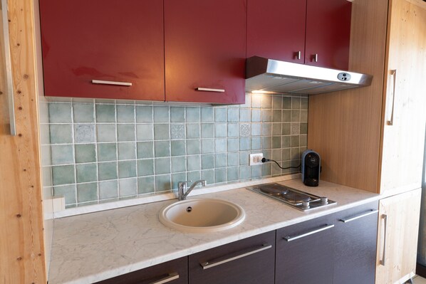 A kitchen with a sink, countertop, and cabinets.