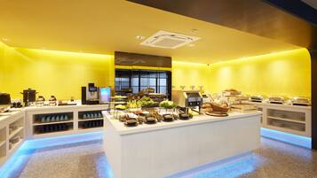 A modern breakfast buffet with a central island, shelves with condiments, and a bright yellow color scheme.
