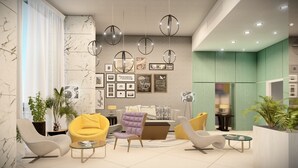 Una sala moderna con pared de mármol, un sofá, sillas amarillas y una mesa de centro.