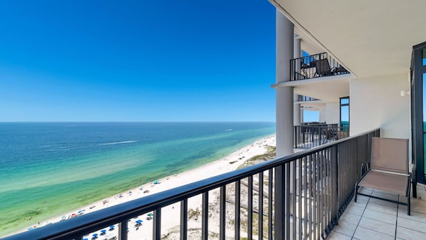 Een balkon met uitzicht op een strand en zee.