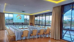 A conference room with a long table, chairs, a podium, and a large screen displaying the logo "MAIYAN". - Storms Resort (Nanyuki)