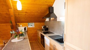 A compact kitchen with wooden walls, a tiled backsplash, a microwave, a coffee maker, and a sink. - Oz/Alpe d'Huez 110m slopes, up to 21 people, Hammam, en-suite bedrooms (Oz)