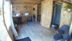 A compact, open-plan cabin with a wooden interior, a kitchenette, two sinks, a small seating area, and a shower. - Nuit Etoilé (Mondragon)