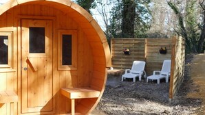 A wooden cabin with a door, windows, and a bench outside. - Nuit Etoilé (Mondragon)