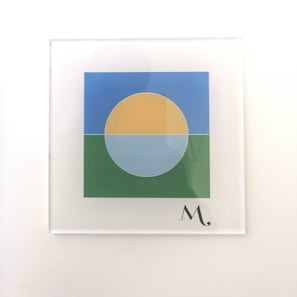A framed artwork with a square format, featuring a central circle divided into three segments of blue, yellow, and green, and the letter 'M' at the bottom. - Mediterra (Castellammare di Stabia)