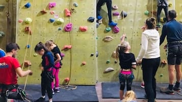 Un gimnasio de escalada con diversas paredes y equipo de seguridad.