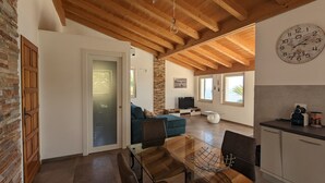 Una sala moderna con techo de madera, televisor y pared de piedra.