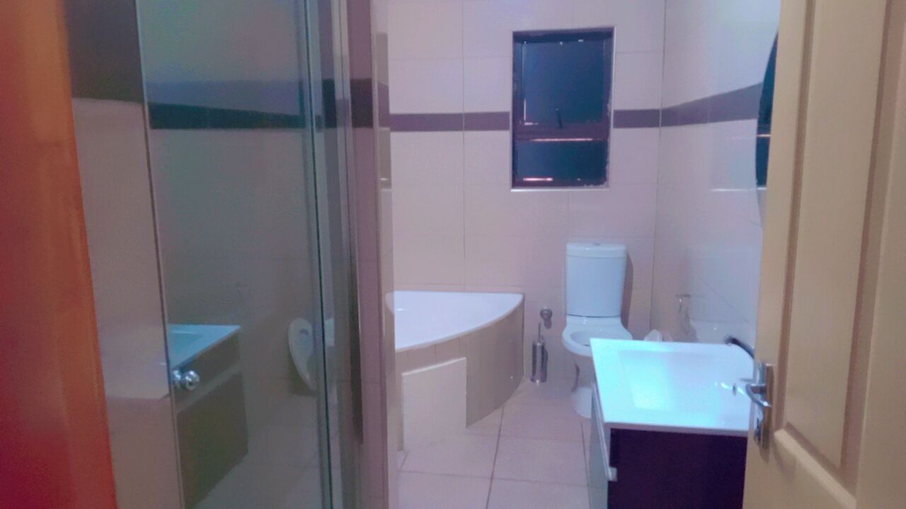 A bathroom with a bathtub, toilet, and sink.