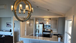A modern kitchen with a central island, stainless steel appliances, and pendant lighting.