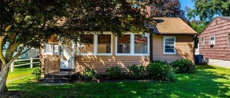 A single-story house with a front porch, a small staircase leading to the entrance, and a well-maintained lawn.