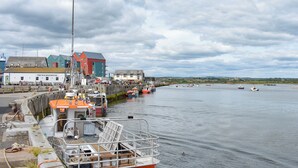 A harbor with boats, a building labeled 'The Old Boathouse,' and a distant view of a town. - 3 bedroom accommodation in Amble, near Morpeth (Amble, near Morpeth)