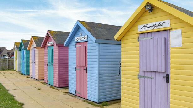 A row of colorful beach huts with doors, each labeled with a name. - 3 bedroom accommodation in Amble, near Morpeth (Amble, near Morpeth)