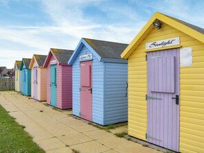 A row of colorful beach huts with doors, each labeled with a name. - 3 bedroom accommodation in Amble, near Morpeth (Amble, near Morpeth)