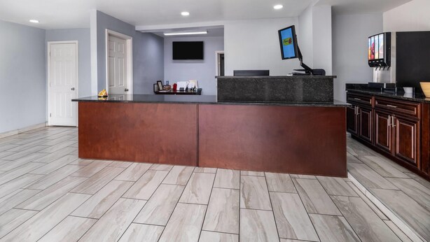 A modern kitchen with a central island, built-in cabinets, and a flat-screen TV mounted on the wall. - Super 8 by Wyndham Portsmouth - Norfolk (Portsmouth)