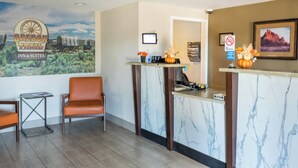 A reception area with a marble counter, a sign for Oregon Trail Inn & Suites, a framed picture on the wall, and a no-smoking sign. - Oregon Trail Inn and Suites (Lakeview)