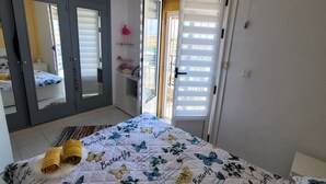A bedroom with a bed, a wardrobe, a mirror, and an air conditioning unit. - House with roof terrace (Torrevieja)