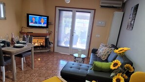 A living room with a TV, a fireplace, a sofa, and a dining area. - House with roof terrace (Torrevieja)