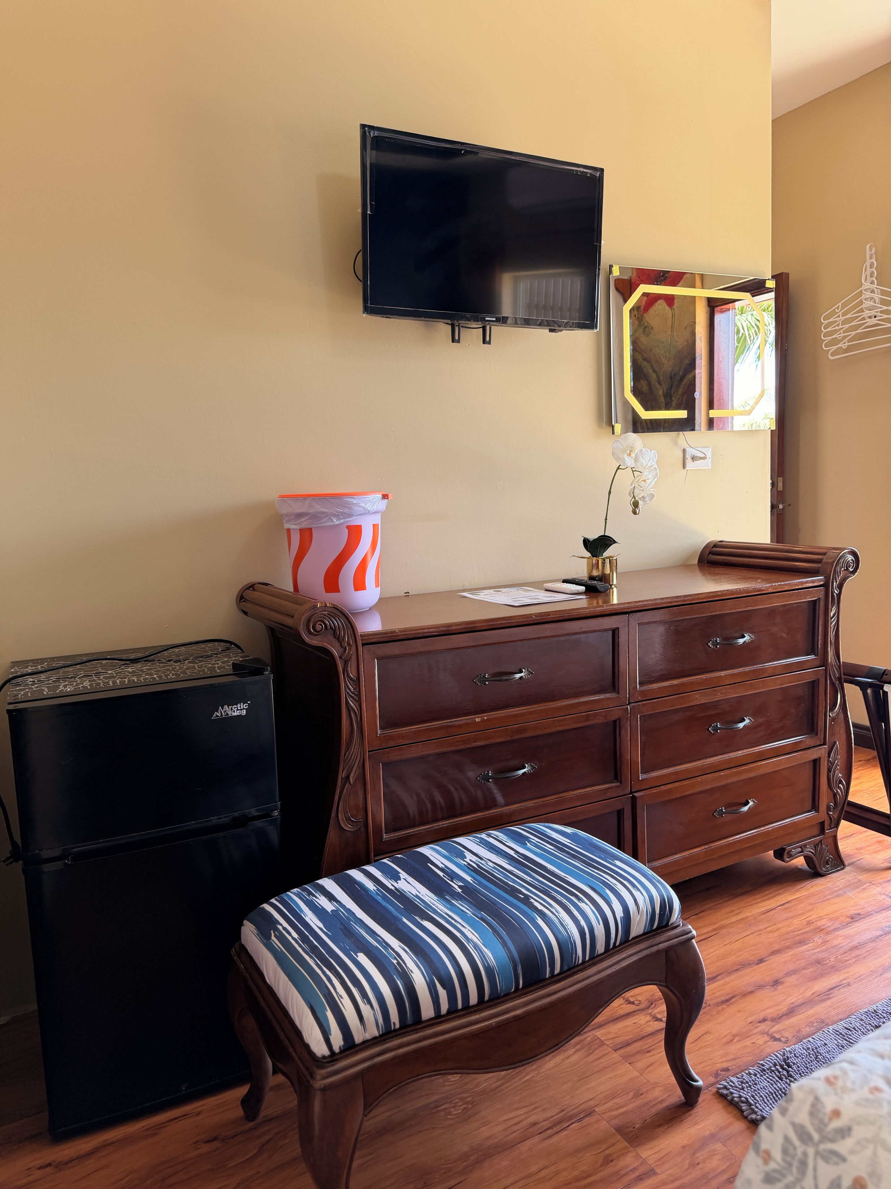 A room with a bed, a dresser, a television, and a small heater.