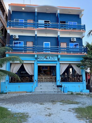 Un edificio de varios pisos con fachada azul y un cartel que dice 'RIO AZU'.