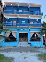 Un edificio de varios pisos con fachada azul y un cartel que dice 'RIO AZU'.