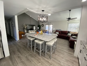 Enjoy cooking and socializing in this kitchen with a central island and bar stools, a comfortable seating area, and a large flat-screen TV.