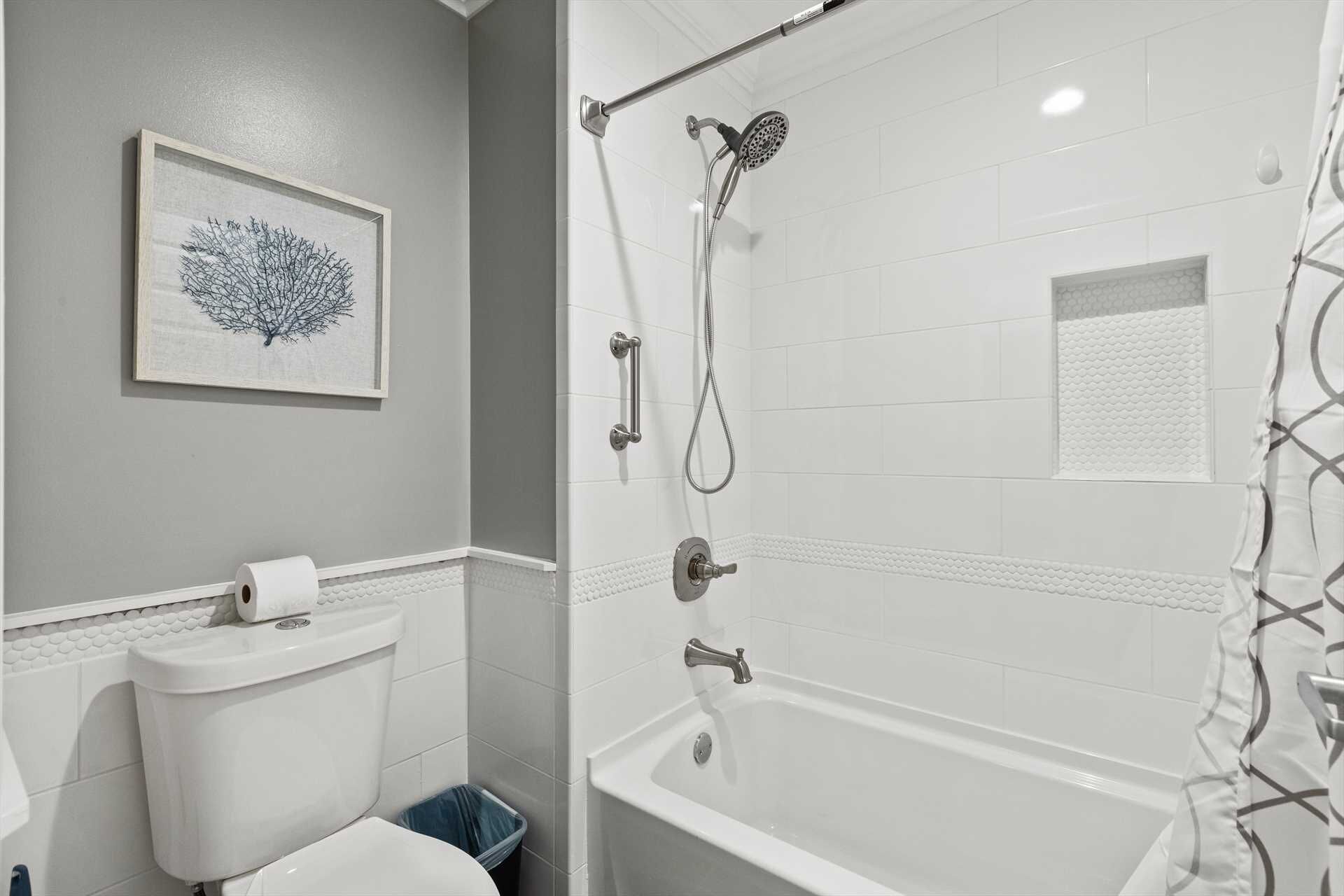 A bathroom with a toilet, a shower, and a sink.