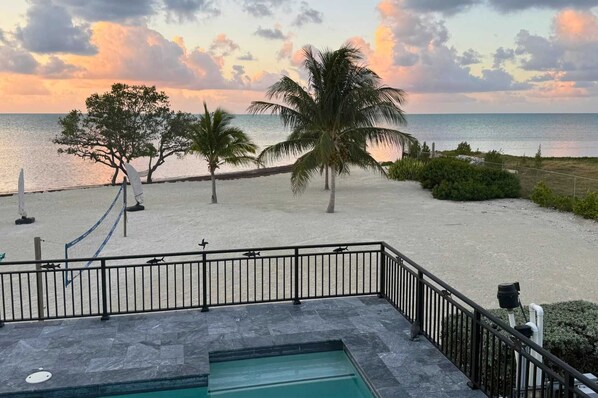 Un espace piscine offrant une vue sur la plage et l’océan.