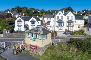 Um hotel à beira-mar com um letreiro grande 'INSTOW', fachada de pedra e área de estacionamento.