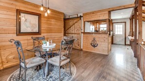 Un intérieur en bois comprenant une table et des chaises, un escalier et un coin cuisine.