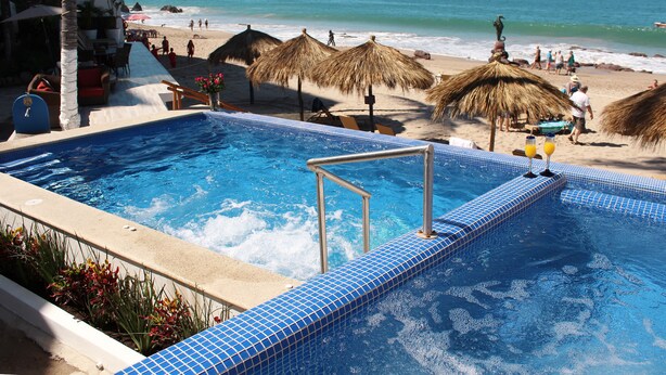 Una piscina con vista a la playa y al océano.