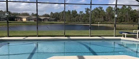 A swimming pool with a view of a lake and houses in the background.