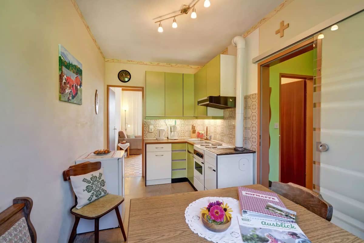 Una cocina compacta con comedor, una mesa pequeña y una silla.