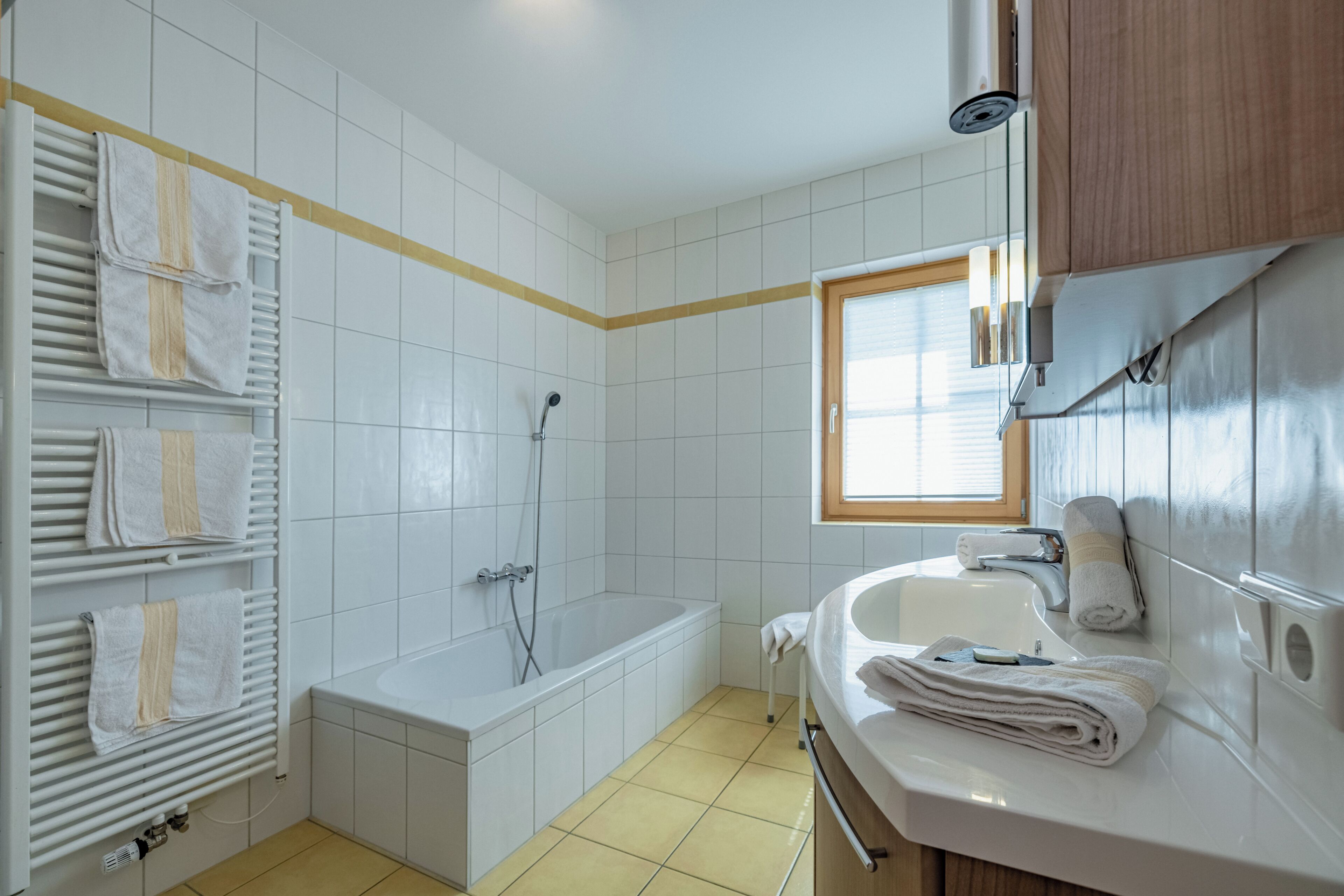 Une salle de bain avec une baignoire, un lavabo et un porte-serviettes.