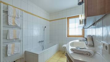 Une salle de bain avec une baignoire, un lavabo et un porte-serviettes.