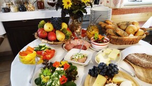 Un tavolo per buffet con diverse pietanze, tra cui frutta, formaggi e pane.