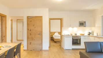 A compact living space with a dining area, kitchenette, and a small bedroom.