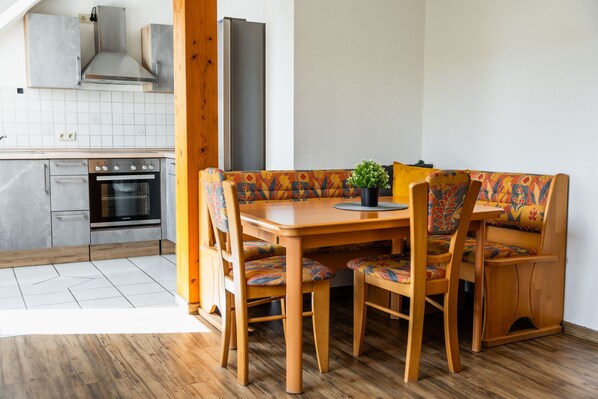 Una cocina moderna con horno empotrado, refrigerador de acero inoxidable y armarios de madera.