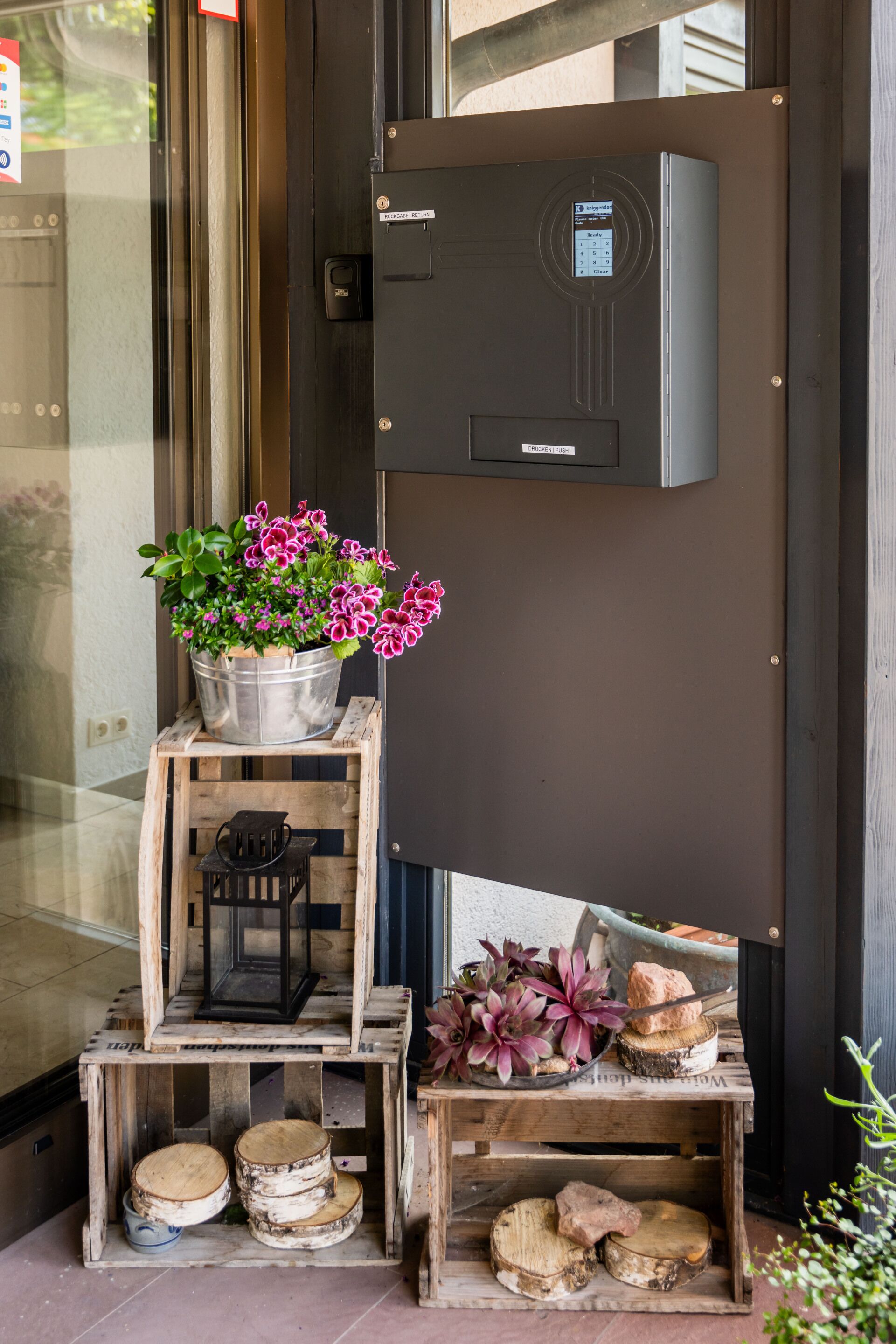 A wooden display with a potted plant, a lantern, and decorative items.